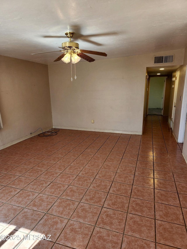 empty room with ceiling fan and light tile patterned floors