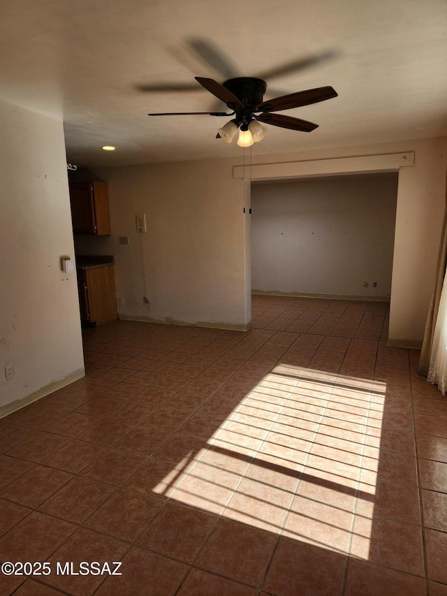 tiled spare room featuring ceiling fan