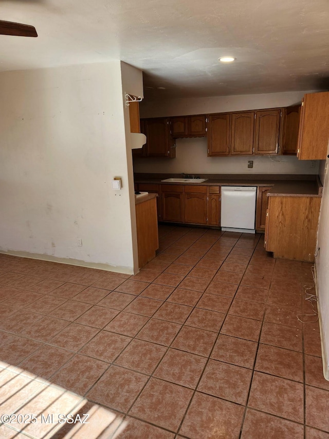 kitchen with sink, dark tile patterned floors, and dishwasher