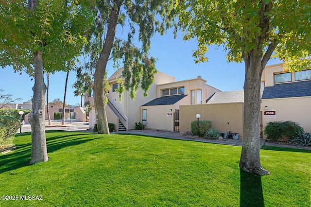 exterior space with a yard and stucco siding