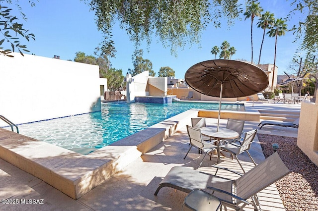 community pool featuring fence and a patio