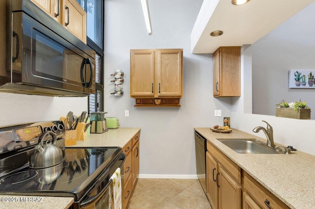 kitchen with light tile patterned floors, a sink, baseboards, light stone countertops, and black appliances