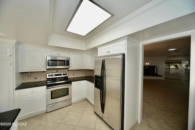 kitchen featuring crown molding, stainless steel appliances, light tile patterned floors, and white cabinets