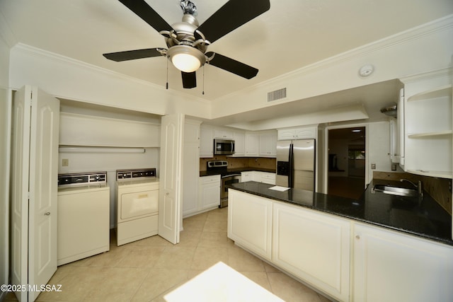 kitchen featuring sink, crown molding, appliances with stainless steel finishes, white cabinetry, and independent washer and dryer