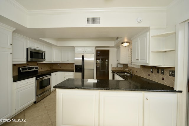 kitchen with light tile patterned flooring, sink, kitchen peninsula, stainless steel appliances, and white cabinets