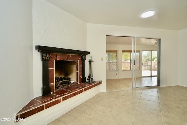 unfurnished living room with tile patterned flooring and a tiled fireplace