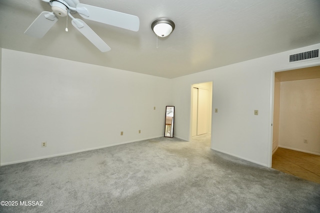 spare room with ceiling fan and light carpet