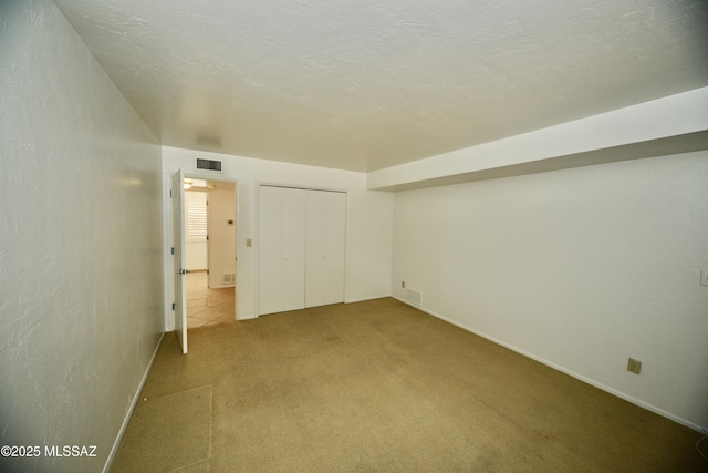 unfurnished bedroom with a closet, carpet floors, and a textured ceiling