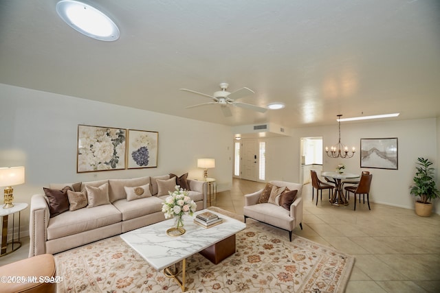 tiled living room with ceiling fan with notable chandelier