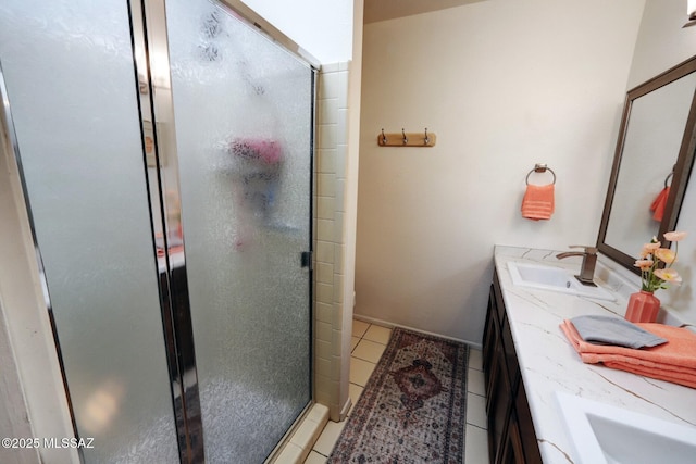 bathroom featuring a shower with door, vanity, and tile patterned flooring