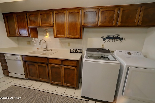 laundry room with sink, light tile patterned floors, and independent washer and dryer