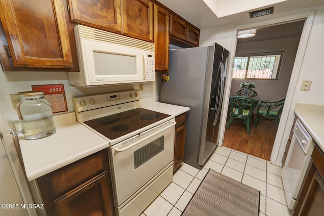 kitchen with light tile patterned floors and white appliances