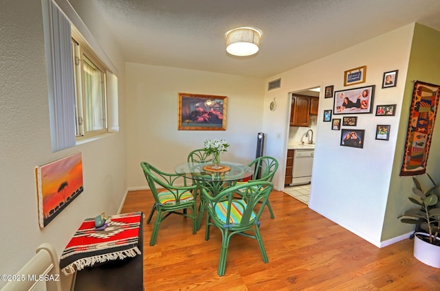 dining room featuring sink and light hardwood / wood-style flooring