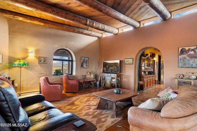 living room with arched walkways, beam ceiling, wooden ceiling, and a high ceiling