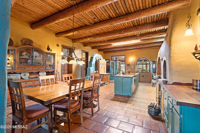 dining room featuring arched walkways, a textured wall, beamed ceiling, and wood ceiling