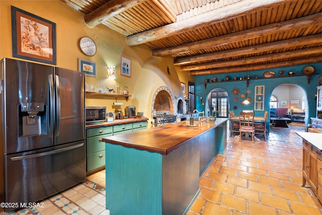 kitchen with arched walkways, wooden counters, green cabinets, appliances with stainless steel finishes, and wooden ceiling