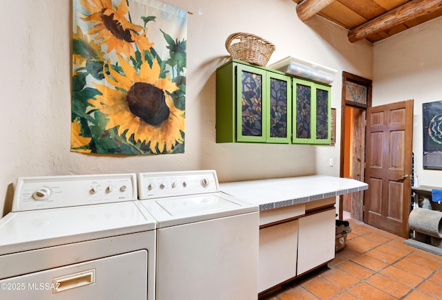 washroom featuring light tile patterned floors, cabinet space, washing machine and clothes dryer, and wood ceiling