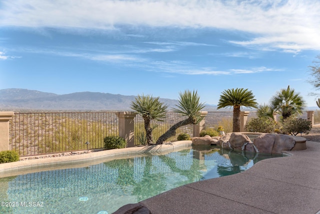 view of pool with a fenced in pool, a mountain view, and fence