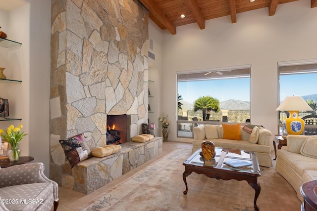 living room featuring wood ceiling, a fireplace, a mountain view, and a wealth of natural light