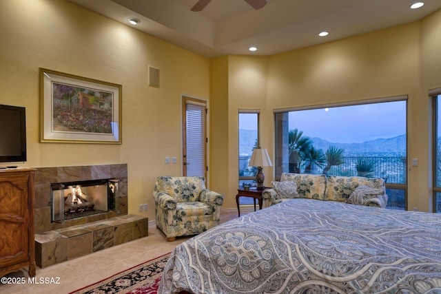 bedroom with tile patterned flooring, a high ceiling, a fireplace, a mountain view, and recessed lighting