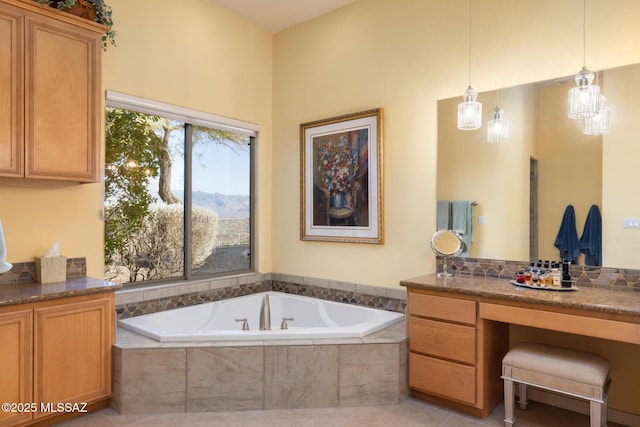 bathroom featuring tile patterned flooring, a bath, and vanity