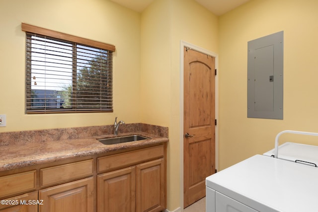 clothes washing area with laundry area, electric panel, washer and dryer, and a sink