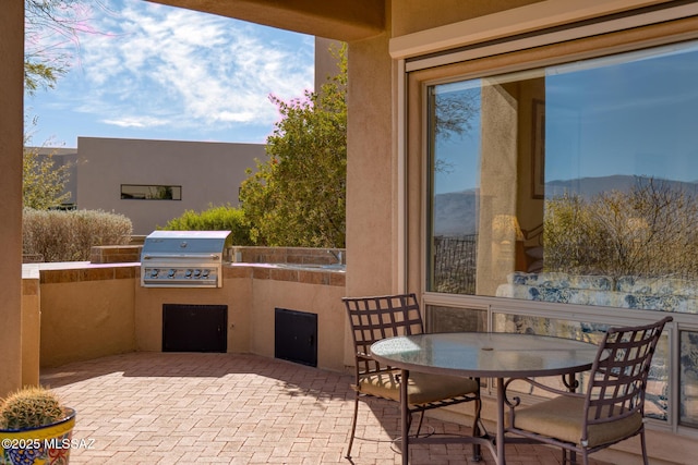 view of patio / terrace with a grill, outdoor dining area, and exterior kitchen