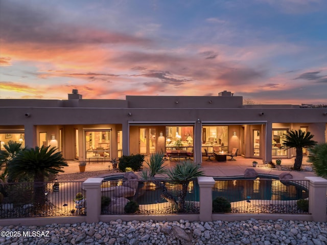 back of property with a patio, a chimney, fence, and a fenced in pool