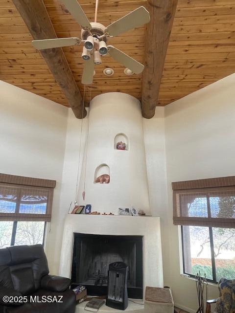 interior space with a large fireplace, beam ceiling, and wooden ceiling