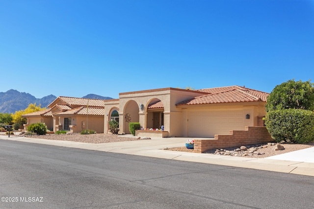 mediterranean / spanish home featuring a garage and a mountain view