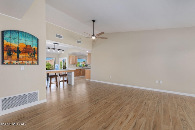 interior space featuring high vaulted ceiling, ceiling fan, and light wood-type flooring