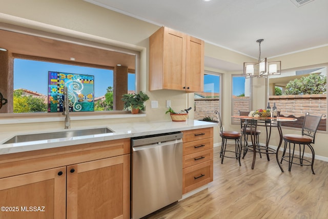 kitchen with light brown cabinets, a sink, light countertops, dishwasher, and decorative light fixtures