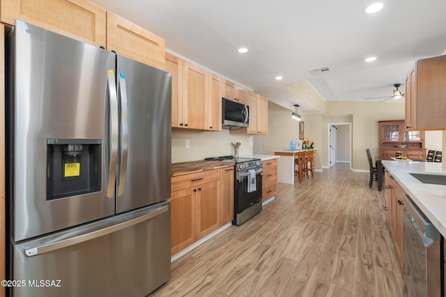 kitchen featuring light brown cabinetry, sink, light wood-type flooring, appliances with stainless steel finishes, and ceiling fan