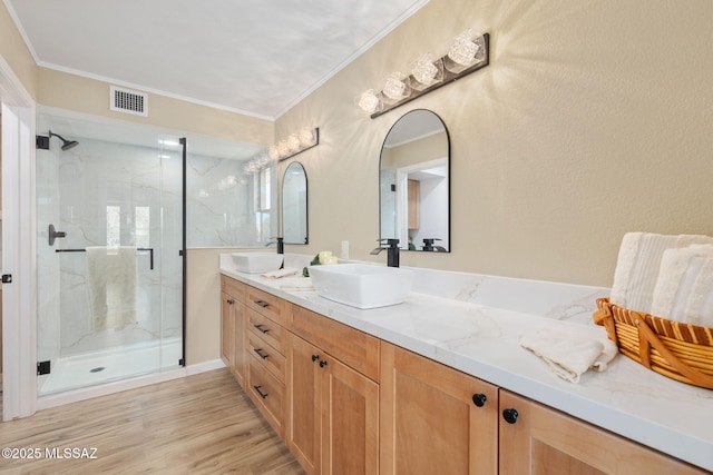 bathroom with vanity, a shower with door, wood-type flooring, and ornamental molding