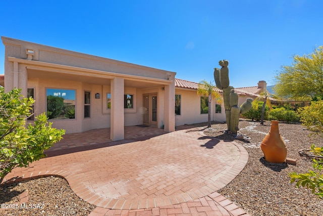 back of house with a patio area, a tile roof, and stucco siding