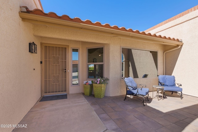 doorway to property with a patio area and stucco siding