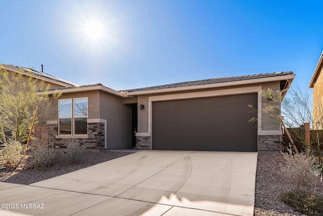 view of front facade featuring a garage, stone siding, driveway, and stucco siding