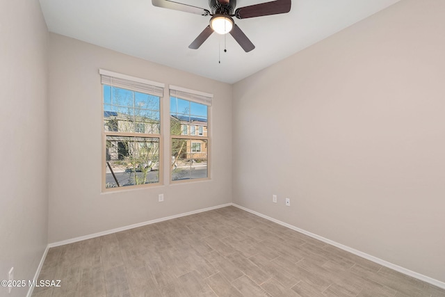 unfurnished room featuring light wood finished floors, ceiling fan, and baseboards