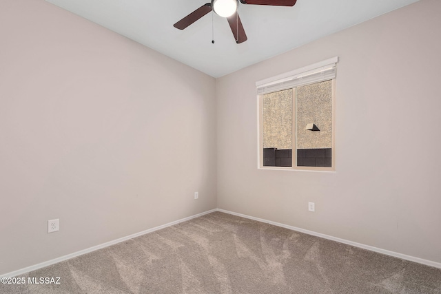 carpeted spare room featuring ceiling fan and baseboards