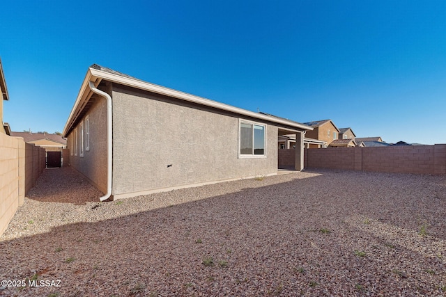 back of property featuring a fenced backyard and stucco siding