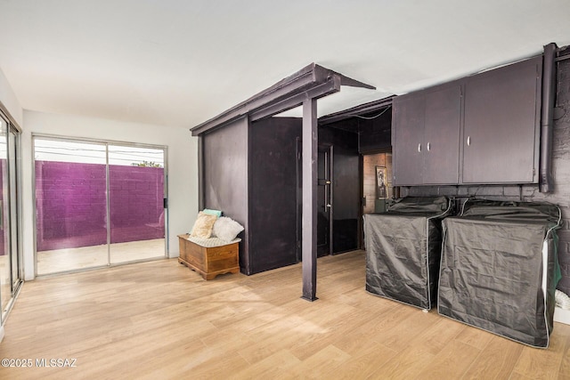 kitchen featuring dark brown cabinetry, independent washer and dryer, and light hardwood / wood-style flooring