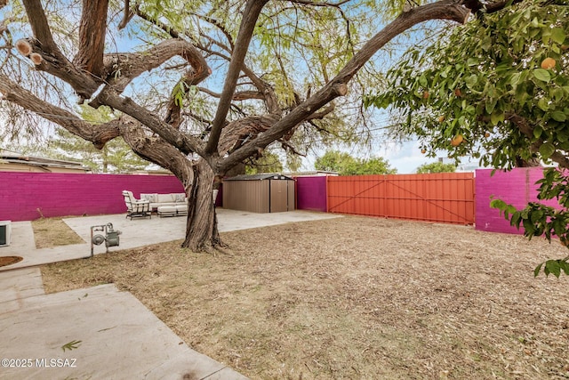 view of yard featuring an outdoor living space, a storage shed, and a patio