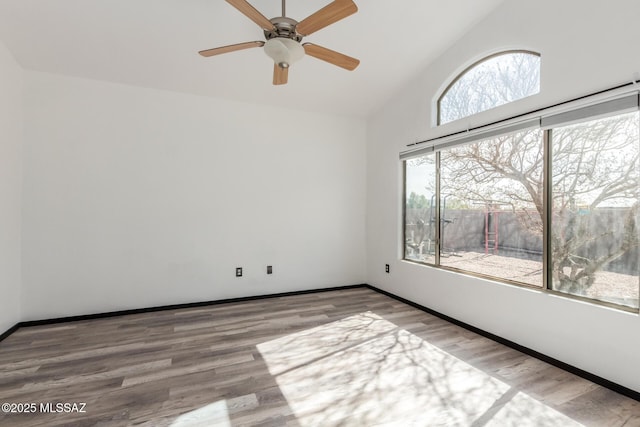 unfurnished room featuring hardwood / wood-style flooring and high vaulted ceiling