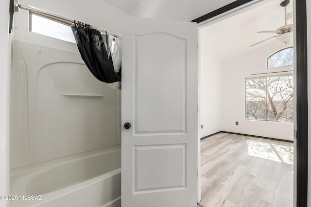 bathroom featuring shower / tub combination, lofted ceiling, hardwood / wood-style floors, and ceiling fan