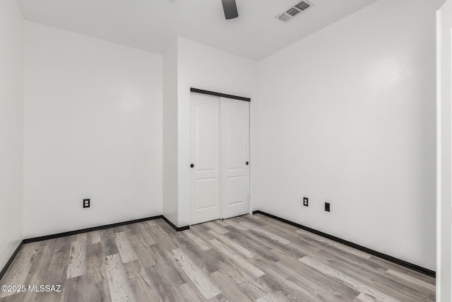 unfurnished bedroom featuring a closet, ceiling fan, and light wood-type flooring