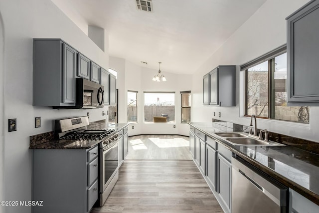 kitchen with gray cabinetry, sink, hanging light fixtures, and appliances with stainless steel finishes