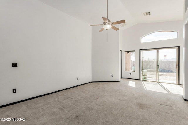 carpeted empty room featuring ceiling fan and high vaulted ceiling