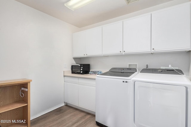 laundry area with cabinets, hardwood / wood-style flooring, and washer and clothes dryer