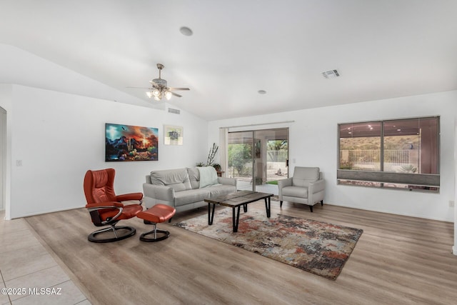 living room with vaulted ceiling, ceiling fan, and light wood-type flooring