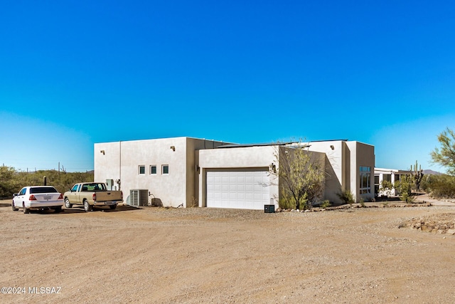 exterior space with a garage and central air condition unit